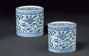 A pair of cricket jars with colorful intertwined branches and floral patterns